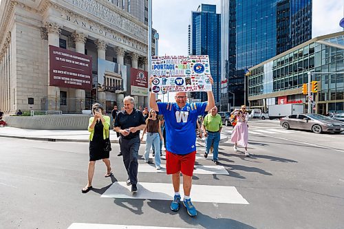 MIKE DEAL / FREE PRESS
Once crossing the street at Portage and Main became official Dancing Gabe along with huge crowds of people make their way around to each of the crosswalks.
The day of the official opening of the pedestrian crosswalks at the historic intersection of Portage Avenue and Main Street started with crews clearing away the last of the barriers and impatient people crossing despite those barriers.
The Mayor, Scott Gillingham and several city council members, along with may of the stakeholders for the buildings at each of the corners of the intersection were on hand with several hundred members of the public who cam to cheer and be some of the first to cross after the opening.
Dancing Gabe was on hand to lead a huge crowd around each of the intersections.
Reporter: Tyler Searle
250627 - Friday, June 27, 2025.