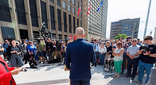 MIKE DEAL / FREE PRESS
Mayor Scott Gillingham speaks to the assembled crowd before walking across the street making the official opening of the pedestrian crosswalks.
The day of the official opening of the pedestrian crosswalks at the historic intersection of Portage Avenue and Main Street started with crews clearing away the last of the barriers and impatient people crossing despite those barriers.
The Mayor, Scott Gillingham and several city council members, along with may of the stakeholders for the buildings at each of the corners of the intersection were on hand with several hundred members of the public who cam to cheer and be some of the first to cross after the opening.
Dancing Gabe was on hand to lead a huge crowd around each of the intersections.
Reporter: Tyler Searle
250627 - Friday, June 27, 2025.