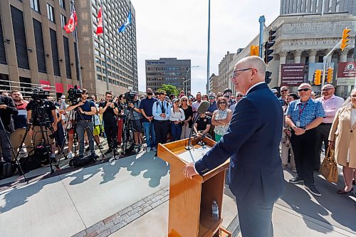 MIKE DEAL / FREE PRESS
Mayor Scott Gillingham speaks to the assembled crowd before walking across the street making the official opening of the pedestrian crosswalks.
The day of the official opening of the pedestrian crosswalks at the historic intersection of Portage Avenue and Main Street started with crews clearing away the last of the barriers and impatient people crossing despite those barriers.
The Mayor, Scott Gillingham and several city council members, along with may of the stakeholders for the buildings at each of the corners of the intersection were on hand with several hundred members of the public who cam to cheer and be some of the first to cross after the opening.
Dancing Gabe was on hand to lead a huge crowd around each of the intersections.
Reporter: Tyler Searle
250627 - Friday, June 27, 2025.