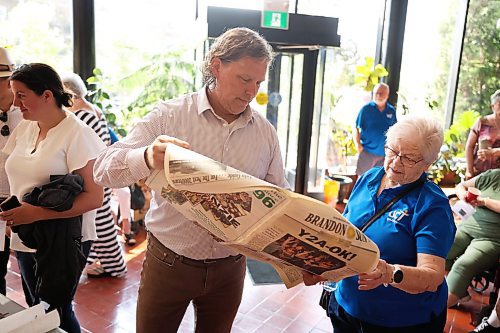 Brandon Mayor Jeff Fawcett reads a Jan. 1, 2000 copy of The Brandon Sun at Brandon City Hall on Friday morning. The newspaper was among the contents of the time capsule that was buried almost 25 years ago. (Tim Smith/The Brandon Sun)