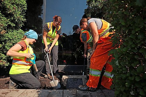 City of Brandon workers dig up the time capsule outside city hall on Friday. (Tim Smith/The Brandon Sun)