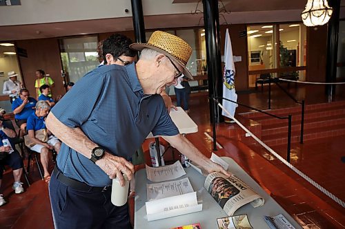Former Brandon mayor Reg Atkinson looks at a Jan. 1, 2000 copy of The Brandon Sun at city hall on Friday morning. The newspaper was among the contents of the time capsule. (Tim Smith/The Brandon Sun)