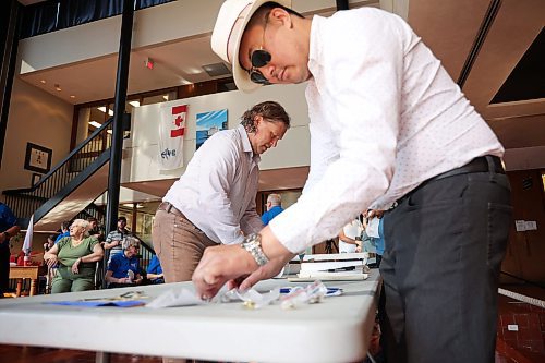 04072025
Brandon Mayor Jeff Fawcett and City of Brandon Senior Planner Andrew Mok organize the contents of the Brandon 2000 Millennium Time Capsule, which was buried in a garden outside Brandon City Hall 25 years ago. The time capsule was created by the United Commercial Travelers (UCT) as part of Brandon City Council’s call-out for local organizations to create ways to celebrate the millennium.
(Tim Smith/The Brandon Sun)