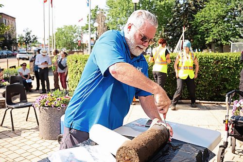 04072025
Eldon Schmitz with the United Commercial Travelers (UCT) prepares to open the Brandon 2000 Millennium Time Capsule, which was buried in a garden outside Brandon City Hall 25 years ago. The time capsule was created by the United Commercial Travelers (UCT) as part of Brandon City Council’s call-out for local organizations to create ways to celebrate the millennium. Brandon Mayor Jeff Fawcett unveiled the contents to the crowd at city hall. (Tim Smith/The Brandon Sun)