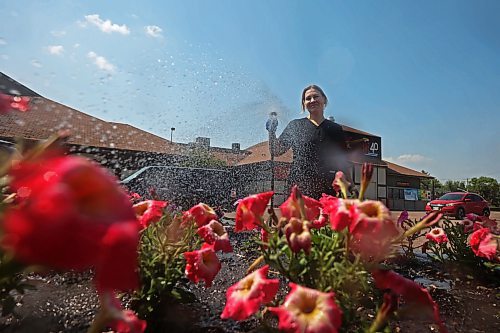 08072025
Housekeeping worker Maryna Fisun of Ukraine waters flowers outside the Travelodge on 18th Street N. in Brandon on Tuesday.
(Tim Smith/The Brandon Sun)