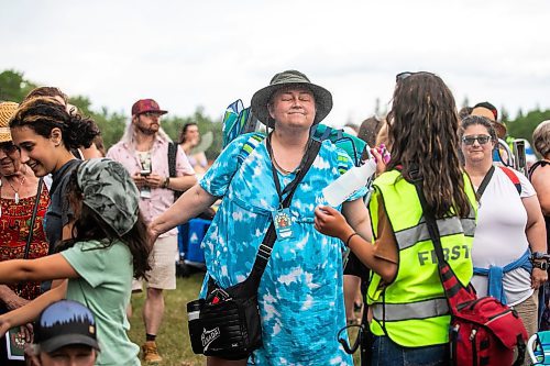 MIKAELA MACKENZIE / FREE PRESS
	
Tiphanie Kroeker enjoys being spritzed with water while waiting in line before the gates open at Folk Fest on Thursday, July 10, 2025. 

For folk fest story.
Winnipeg Free Press 2025