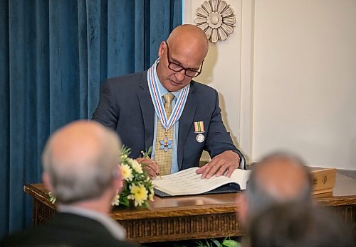 BROOK JONES/FREE PRESS
The Order of Manitoba, Manitoba's highest honour, was presented to 12 recipients during an investiture ceremony in the Manitoba Room at the Manitoba Legislative Building in Winnipeg, Man., Thursday, July 17, 2025. Pictured: Gordon Giesbrecht, who is renowned for his research in cold stress physiology, signs the registry for the Order of Manitoba.