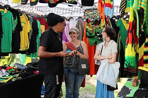 Warren Benns, owner of Natural Mystic shares a laugh with Stacey and Izzy Eaton at the Naija Market in Princess Park Saturday afternoon in downtown Brandon. (Michele McDougall/The Brandon Sun)