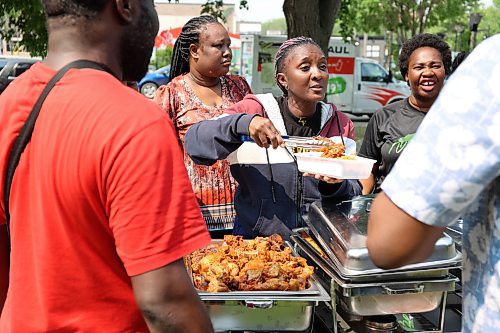 A food vendor piles on the chicken for a customer during the Naija Market in Princess Park Saturday afternoon in downtown Brandon. (Michele McDougall/The Brandon Sun) 