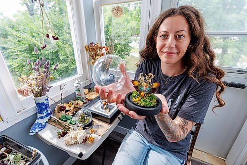 MIKE DEAL / FREE PRESS
Randi holds up a stunning piece that includes a Lantern Fly.
Randi Thomson creates entomological art, using preserved bugs and insects and native grasses and plants to make her bug landscapes. She mounts the flora and fauna in cloches, bell jars and vintage receptacles. Her garden in Stonewall, MB, is full of bones, gifted to her by family, friends and neighbours.
Reporter: AV Kitching
250707 - Monday, July 07, 2025.