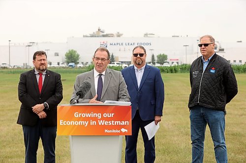 Agriculture Minister Ron Kostyshyn speaks as Municipal and Northern Relations Minister Glen Simard, Canada Packers Inc. director of operations Rob Ackerblade and Maple Leaf Foods plant manager Jim Brown look on during an announcement by the province at Maple Leaf Foods in Brandon on Wednesday. (Tim Smith/The Brandon Sun)