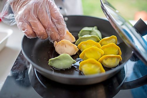 BROOK JONES/FREE PRESS
Aaron Li, who moved to Winnipeg with his family in 2022, markets Chinese dumplings based on family recipes and sells his dumplins at the Wolseley Farmers Market at Saint Margaret's Anglican Church in Winnipeg, Man. Li has a variety of dumplings such as pork with cabbage and chive, tofu with kimchi and beef with carrots and onion. Pictured: Li, 37, places dumplings on a portable induction cooktop at his Super Flying Dumpling booth during the Wolseley Farmers Market Tuesday, July 29, 2025.