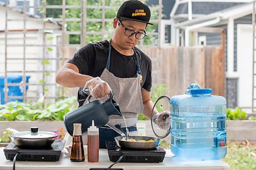 BROOK JONES/FREE PRESS
Aaron Li, who moved to Winnipeg with his family in 2022, markets Chinese dumplings based on family recipes and sells his dumplins at the Wolseley Farmers Market at Saint Margaret's Anglican Church in Winnipeg, Man. Li has a variety of dumplings such as pork with cabbage and chive, tofu with kimchi and beef with carrots and onion. Pictured: Li, 37, adds water while he is preparing dumplings on a portable induction cooktop at his Super Flying Dumpling booth during the Wolseley Farmers Market Tuesday, July 29, 2025.