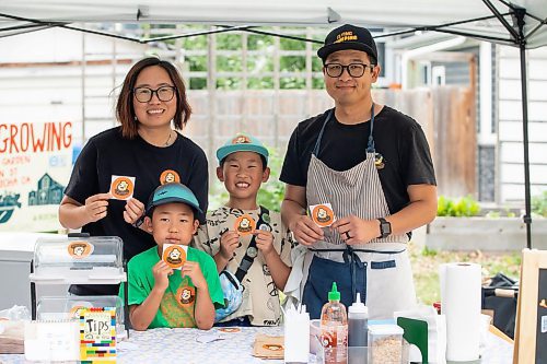 BROOK JONES/FREE PRESS
Aaron Li, who moved to Winnipeg with his family in 2022, markets Chinese dumplings based on family recipes and sells his dumplins at the Wolseley Farmers Market at Saint Margaret's Anglican Church in Winnipeg, Man. Li has a variety of dumplings such as pork with cabbage and chive, tofu with kimchi and beef with carrots and onion. Li, 37, (right) is pictured logo sitckers at his Super Flying Dumpling booth with his wife Ruby Zhao, 36, (left) and their children Jasper Li, 6, (second from far left) and Oscar Li, 8, (second from far right) during the Wolseley Farmers Market Tuesday, July 29, 2025.