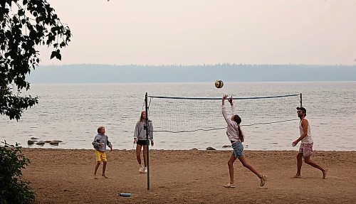 James McCammon (R) and his children (L-R) Wesley, Liv and Maddy, play volleyball on the Clear Lake beach in Wasagaming on a very smoky Tuesday afternoon. (Tim Smith/The Brandon Sun)