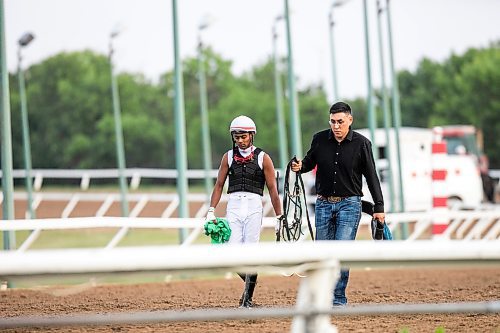 MIKAELA MACKENZIE / FREE PRESS
Jockey Sven Balroop and trainer Steve Keplin Jr. walk away from the horse medical vehicles after the second race on Manitoba Derby night at the Assiniboia Downs on Monday, Aug. 4, 2025.
For photo page.
Winnipeg Free Press 2025