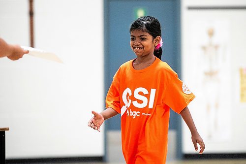 MIKAELA MACKENZIE / FREE PRESS
	
Junaterah Mohammad Salim walks up to get her participation certificate at the CSI Summer Learning Enrichment Program graduation ceremony at Sister MacNamara on Wednesday, Aug. 6, 2025. The CSI program offers educational and recreational programming for five weeks in the summer.

Standup.
Winnipeg Free Press 2025