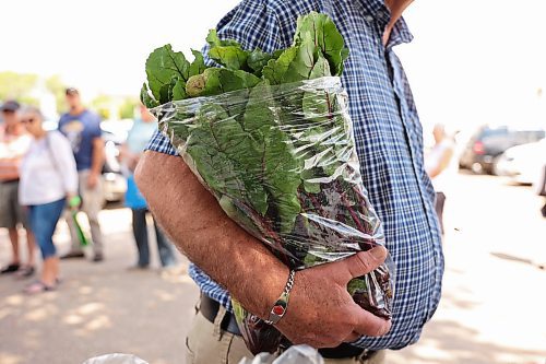 06082025
Wayne Zalluski holds a bag of beets while shopping at Spring Valley Colony’s weekly summer produce market on 18th Street in the BellMTS Admin Building parking lot, Wednesday. A crowd was already waiting as colony members set up the market. Julie Waldner, the Head Gardener at Spring Valley sees both regular weekly customers as well as new faces. The market ran from 12PM and included a wide assortment of vegetables including cucumbers, beans, lettuce, garlic, broccoli, zucchini, beets and much more. (Tim Smith/The Brandon Sun)