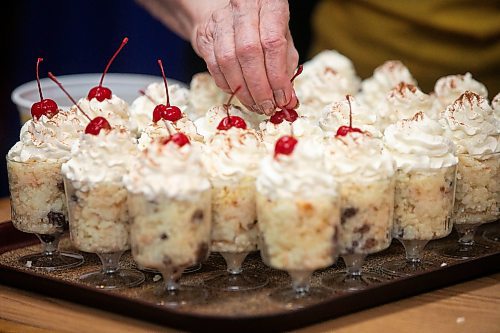 MIKAELA MACKENZIE / FREE PRESS
	
Rice pudding gets topped with whipped cream, cinnamon, and a cherry for the second week of Folklorama at the Belgian Club on Monday, Aug. 11, 2025. They started the week with 64 litres of whipping cream ready for waffles and desserts.

Standup.
Winnipeg Free Press 2025