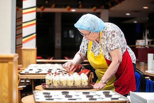 MIKAELA MACKENZIE / FREE PRESS
	
Ida Aquin puts cherry garnishes onto the rice pudding desserts for the second week of Folklorama at the Belgian Club on Monday, Aug. 11, 2025. They started the week with 64 litres of whipping cream ready for waffles and desserts.

Standup.
Winnipeg Free Press 2025