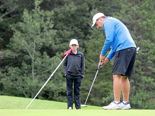 Nolan Tutkaluk, right, rolls in one of his six birdies on Sunday as his son and caddie Austin looks on. (Thomas Friesen/The Brandon Sun)