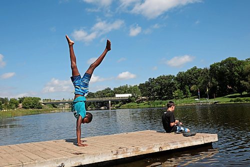 19082025
Kai Denbow walks on his hands as his friend Nathan Holden fishes from a dock along the Souris River in Souris on a hot Tuesday.
(Tim Smith/The Brandon Sun)