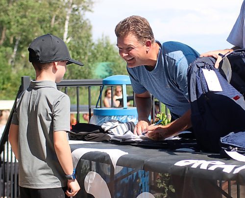 Tamarack president Jason Curtis, right, hands out swag bags after the Cubs' round. (Thomas Friesen/The Brandon Sun)