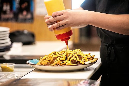 MIKAELA MACKENZIE / FREE PRESS
Wynnie Doan, co-owner of Vickie's Snack Bar, serves up a massive volcano poutine at the burger shop in Beausejour on Tuesday, Aug. 19, 2025.
For Dave Sanderson story.
Winnipeg Free Press 2025