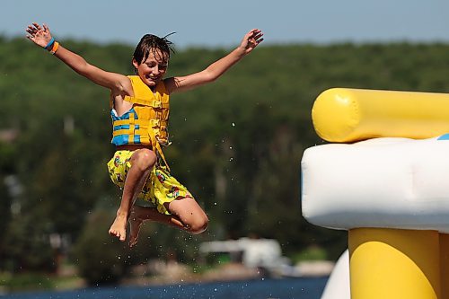 Jack Kirk leaps off the top of a tower into Minnedosa Lake at the Splish Splash Water Park on Thursday. The water park's co-owner, Connor Champagne, says the improved condition of the lake has meant a rebound for the business. (Tim Smith/The Brandon Sun)