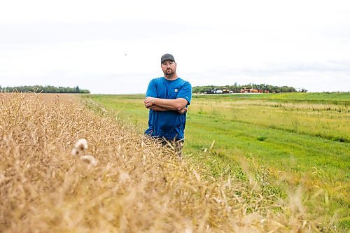 MIKAELA MACKENZIE / FREE PRESS
	
Dustin Wiens, a grain farmer south of La Salle, in his canola field by the road closure of Floodway Road on Monday, Aug. 25, 2025. The road, which is closed now through to October, will impact the way that he transports his harvest from the fields.

For Aaron story.
Free Press 2025