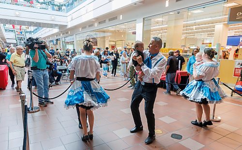 MIKE DEAL / FREE PRESS
Kevin Chief holds a baby while dancing with the Norman Chief Memorial Dancers who were part of the entertainment during a “Love Your Downtown” community celebration event at Portage Place hosted by True North Real Estate Development (TNRED). The Wednesday afternoon event drew crowds to the mall which is still open for business during the construction of the Healthcare Centre of Excellence in the east block. Several community leaders dropped by to chat with people and take in the entertainment which included hoop dancers, and a fashion show.
250827 - Wednesday, August 27, 2025.