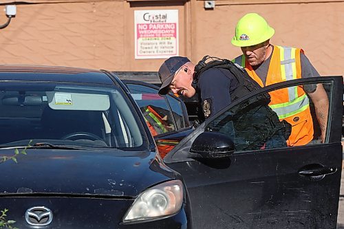 27082025
A Brandon Police service member looks through a car parked at the Crystal Hotel in Brandon on Wednesday morning. (Tim Smith/The Brandon Sun)
