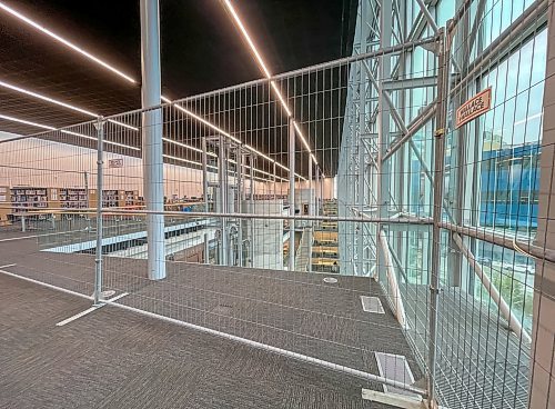 MIKE DEAL / FREE PRESS
The Millennium library’s fourth floor reopened Tuesday with additional safety measures including a portable metal fence keeping people away from the railing, following a suicide earlier this month. 
Reporter: Nicole Buffie
250902 - Tuesday, September 02, 2025.