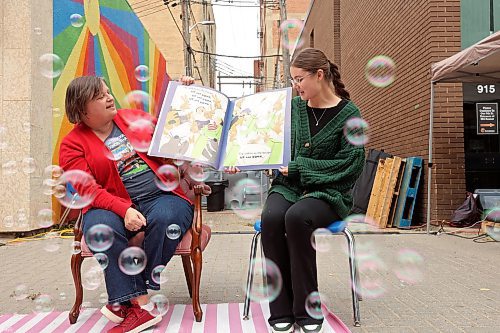 29082025
Robin Stewart  and Leah Stephens with the Brandon Public Library read to children and their parents during the final Downtown Summer Market of the season on Rosser Avenue in downtown Brandon on Wednesday. 
Tim Smith/The Brandon Sun)