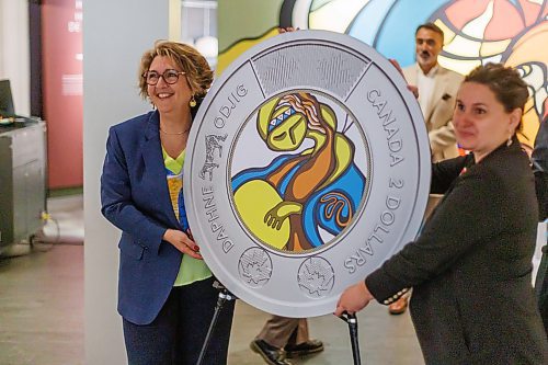 MIKE DEAL / FREE PRESS
Marie Lemay (left), CEO of the Royal Canadian Mint, and Dorota Blumczynska (right), CEO of the Manitoba Museum, hold up an enlarged replica two-dollar coin showcasing Daphne Odjig’s art.
The Royal Canadian Mint unveils a special two-dollar circulation coin recognizing artist, Daphne Odjig, and her contributions to the transformation of Indigenous art at a ceremony inside the Manitoba Museum in front of a mural she painted in 1972 titled, The Creation of the World.
250904 - Thursday, September 04, 2025.