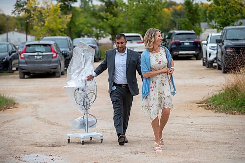 BROOK JONES/FREE PRESS
The Victoria Hospital Foundation hosts its 10th anniversary Miracle Garden Party at Le Marché St. Norbert Farmers' Market in Winnipeg, Man., Thursday, Sept. 11, 2025. Victoria Hospital Business and Finance Lead Anthony Lokke (left) is pictured wheeling a Butterfly Portable Ultrasound through the parking lot for the event.