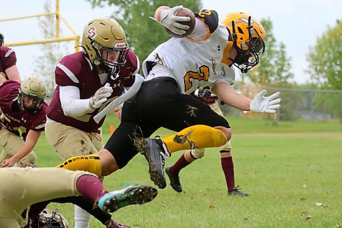 Ryan Martin squeezes through a pair of Crocus Plains tacklers in top tier action Sept. 11 in Brandon. The Grade 11 player carried the ball five times for 36 yards in the game, chipping in with a 36-yard field goal as well the Sabres moved to 2-0 on the season, taking down the Plainsmen 31-6, thanks to another strong defensive and run game performance. Steinbach are next at home Sept. 26 when they take on Dakota. (Thomas Friesen Brandon Sun)