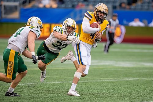 BROOK JONES/FREE PRESS
The University of Manitoba Bisons host the visiting University of Alberta Golden Bears in Canada West football action at Princess Auto Stadium in Winnipeg, Man., Saturday, Sept. 20, 2025. Pictured: Bisons quarterback Jackson Tachinski (No. 4) runs with the football while Golden Bears linebacker Dayton Ingenhaag (No. 33) tries to tackle him during second quarter action.
