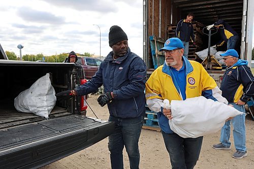 Terry Gunnlaugson (right), a member Wheat City Lions Club, heaves a bag of potatoes into the back of a pickup truck during last year's annual potato sale. It will once again be held in an empty parking lot on 18th Street on Brandon’s North Hill, directly across from the Kelleher Ford dealership. (Connor McDowell/The Brandon Sun files)