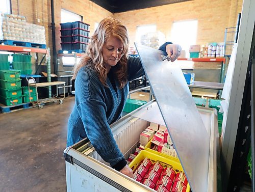 Samaritan House Ministries executive director Heather Symbalisty checks the inventory on the milk cooler at the facility located in downtown Brandon. (Brandon Sun file)