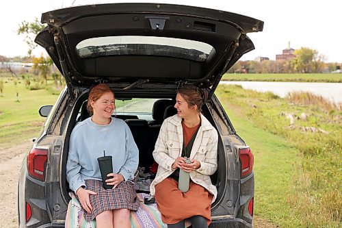 Friends Bethany Penner and Lauren Doerksen visit over lunch at Dinsdale Park in Brandon on a cool, cloudy Monday. Environment Canada is forecasting continued cool weather today, with a high of 11 C, but warmer temperatures are expected for the rest of the week. (Tim Smith/The Brandon Sun)