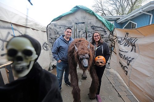 Mike and Carla Mitchell stand in the entryway to their haunted Halloween house with a newly added beast in Brandon. The house will have animatronics, scare actors and creepy passageways to horrify visitors this Halloween season. The project titled &quot;Scare away hunger&quot; comes as guests enter the haunted house by donation of a food item for the local Samaritan House food bank, collected on site. (Connor McDowell/The Brandon Sun)