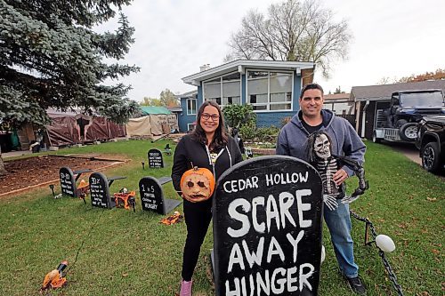 Carla Mitchell and Mike Mitchell stand in the yard in front of their haunted Halloween house, where animatronics, scare actors and passageways will give visitors a scare this month. The title "Scare Away Hunger" comes as guests enter the haunted house by donation of a food item for the local Samaritan House food bank. (Connor McDowell/The Brandon Sun)