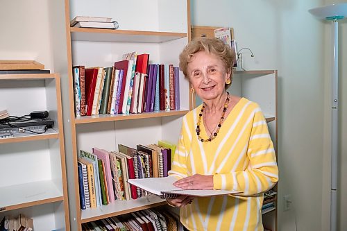 BROOK JONES/FREE PRESS
Winnipeg resident Judy Goodman, 82, who has been journaling since she was 12 years old, stands next to nearly 100 of her journals while she holds one from 2010. Goodman was pictured in her home in Winnipeg, Man., Wednesday, Oct. 15, 2025.