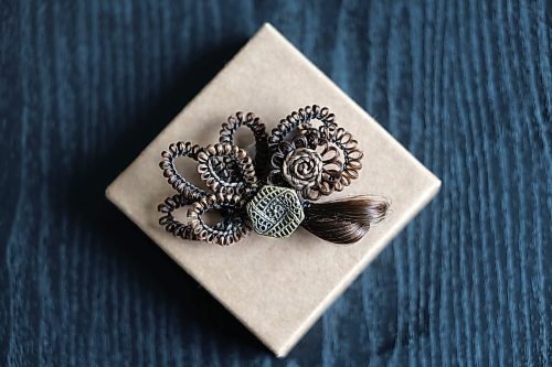 Ruth Bonneville / Free Press
49.8 - Creators
Photo of a hair clip with button and hair.
Local artist, Sandra Klowak with Corporeal Curios, who creates artwork from hair, in her studio with samples of her work.
Story: Sandra Klowak creates artwork from hair for clients who donate hair of their loved ones who have died. It’s a form of sculpture which originated in the Victorian era.
Klowak has recently begun incorporating teeth – donated from friends and family members – into her personal artwork.
Oct 15, 2025