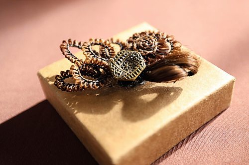 Ruth Bonneville / Free Press
49.8 - Creators
Photo of a hair clip with button and hair.
Local artist, Sandra Klowak with Corporeal Curios, who creates artwork from hair, in her studio with samples of her work.
Story: Sandra Klowak creates artwork from hair for clients who donate hair of their loved ones who have died. It’s a form of sculpture which originated in the Victorian era.
Klowak has recently begun incorporating teeth – donated from friends and family members – into her personal artwork.
Oct 15, 2025