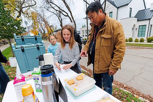 MIKE DEAL / FREE PRESS
Annie MacDonald puts a lid on a drink for neighbour Vic Lee Thursday morning.
Every Thursday morning since the beginning of September Jennie MacDonald’s nine-year-old daughter Annie has been setting up a coffee stand on the corner of their street to raise money for CancerCare Manitoba.
Reporter: Eva Wasney
251016 - Thursday, October 16, 2025.