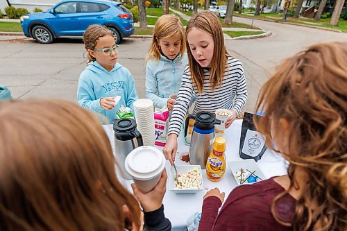 MIKE DEAL / FREE PRESS
Annie MacDonald (stripped shirt) along with her friends Ruby Kurz (left), 9, and Olenka Cardwell (centre), 9, prepares a drink for customers at the corner of Waterloo Street and Kingsway.
Every Thursday morning since the beginning of September Jennie MacDonald’s nine-year-old daughter Annie has been setting up a coffee stand on the corner of their street to raise money for CancerCare Manitoba.
Reporter: Eva Wasney
251016 - Thursday, October 16, 2025.