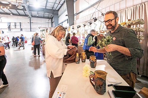 MIKAELA MACKENZIE / FREE PRESS
Joanne Sponarski-Mynott buys pottery from Shaun Dyckճ booth at Scattered Seeds Craft Market on Friday, Oct. 17, 2025.
For Aaron story.
Free Press 2025