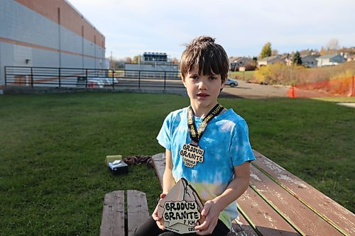 Eight-year-old Samuel Chiupka with his plaque and medal won at the 2025 Groovy Granite seven-kilometre race in Lac du Bonnet recently. (Abiola Odutola/The Brandon Sun)